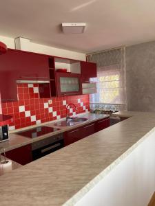 a kitchen with red cabinets and a sink at Astralis Factory Apartments- FLY in Zagreb