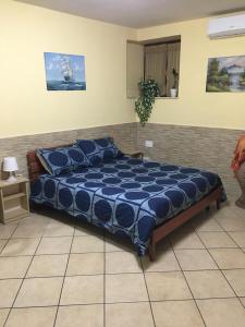 um quarto com uma cama com um edredão azul em B&B Corte Fenza em Nocera Inferiore