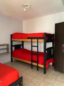 Ce dortoir comprend 2 lits superposés et des draps rouges. dans l'établissement Go Hostel, à Córdoba