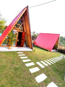ein kleines Haus mit rotem Dach auf dem Gras in der Unterkunft CABAÑAS ALPINA in San Agustín