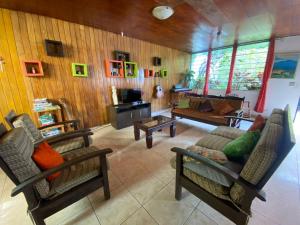 - un salon avec deux chaises et un canapé dans l'établissement Hostal Cumbres del Volcán Escalón, à San Salvador