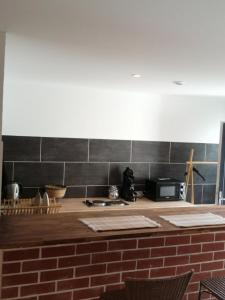 a kitchen with a counter top with a brick wall at Maison Natis in Tillé