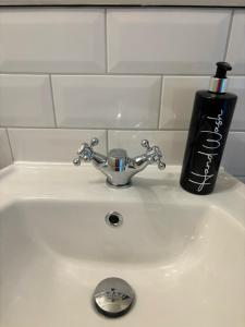 a sink with a toothbrush and a black soap bottle at The Old Postie Bed & Breakfast in Annesley