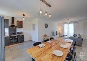 cocina y sala de estar con mesa de madera en La Choisille / Maison 3 chambres en Cerelles