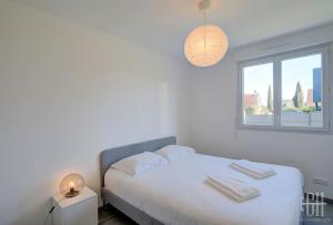 Habitación blanca con cama y ventana en La Choisille / Maison 3 chambres en Cerelles