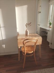 a dining room table with a chair and a kitchen at Viihtyisä ja valoisa yksiö keskustan läheisyydessä in Heinola