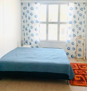 a bedroom with a blue bed and a window at Villa Win in Lappeenranta