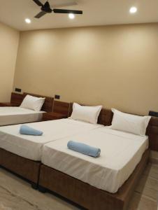 two beds in a room with two blue pillows at Hotel Windsor Plaza in Hyderabad