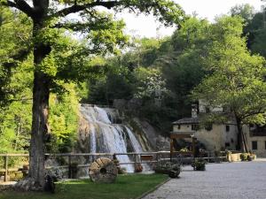 a waterfall next to a building with a tree at Locazione Lilibet in Conegliano