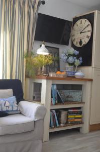 a living room with a couch and a table with a clock at Ropewalk Cottage - A Little Treasure By The Coast in Portaferry