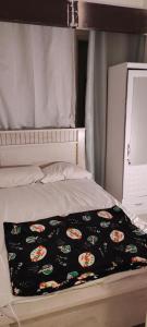 uma cama com um cobertor preto em cima em Couples Room with Window smart TV Fridge em Dubai