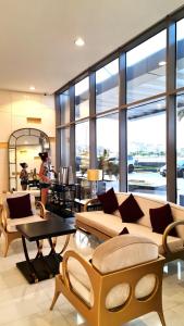 a living room with couches and tables and windows at Beachfront SeaView Home in Lusail