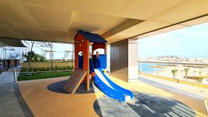 a playground in a building with a slide at Beachfront SeaView Home in Lusail
