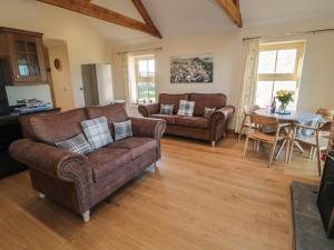 un soggiorno con due divani e un tavolo di Bothy Cottage ad Alnwick