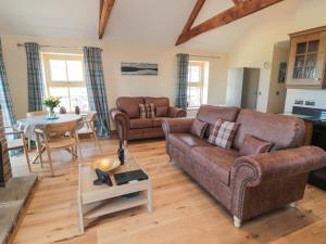 a living room with a couch and a table at Glebe Cottage in Alnwick