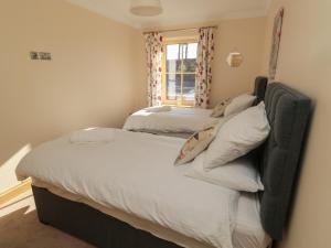 due letti singoli in una stanza con finestra di Bothy Cottage ad Alnwick