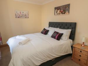 a bedroom with a large white bed with pillows at Glebe Cottage in Alnwick +29 photos