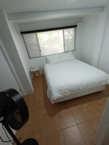 a bedroom with a white bed and a window at Avondale Apartment in Lismore