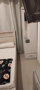 um pequeno quarto com uma cama e um espelho em Couples Room with Window smart TV Fridge em Dubai