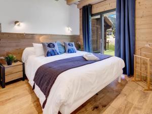 une chambre avec un grand lit blanc avec des oreillers bleus dans l'établissement Résidence La Moutelette - Chalet La Moutelette - 14 Personnes - Montriond MAE-3831, à Montriond