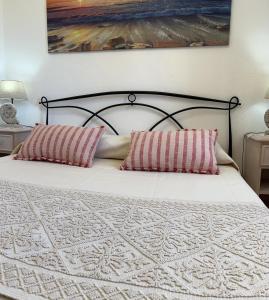 een slaapkamer met een bed met 2 kussens erop bij Casa mare e relax in Pula