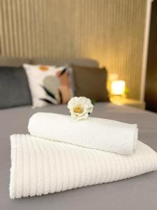 uma toalha branca com uma flor em cima de uma cama em Sol House em Pisa