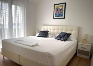 a white bed with two pillows on it in a bedroom at Apartments BINGO in Cavtat