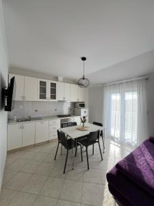 a kitchen and dining room with a table and chairs at Apartments BINGO in Cavtat