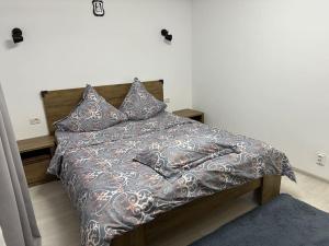 un letto con coperta e cuscini sopra di Apartament de închiriat a Câmpulung Moldovenesc
