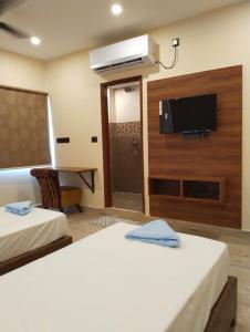 a hotel room with two beds and a flat screen tv at Hotel Windsor Plaza in Hyderabad