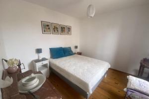 ein kleines Schlafzimmer mit einem Bett und einem Tisch in der Unterkunft Charming house close to the beach in Ouistreham