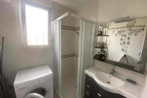ein Badezimmer mit einer Waschmaschine und einem Waschbecken in der Unterkunft Charming house close to the beach in Ouistreham