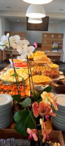 un buffet con muchos tipos diferentes de comida en una mesa en Cambirela Hotel, en Florianópolis