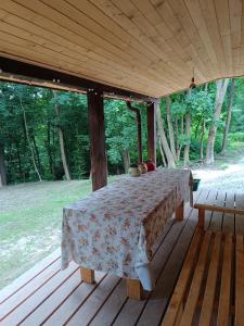 une terrasse en bois avec une table sur une terrasse couverte dans l'établissement Dom całoroczny, à Wojsławice