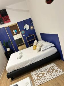 een slaapkamer met een bed met een blauwe muur bij Studio cosy, grand spa privatif et parking privée Centre ville menton in Menton