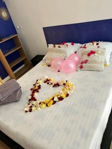 Una cama con un corazón hecho de globos rosados en Studio cosy, grand spa privatif et parking privée Centre ville menton, en Menton