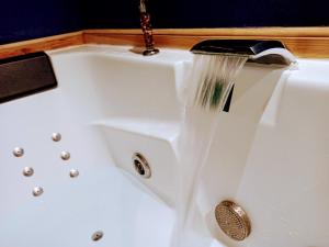 a sink with water flowing from a faucet at Studio cosy, grand spa privatif et parking privée Centre ville menton in Menton