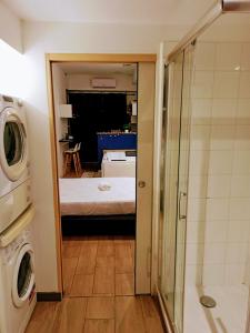 a bathroom with a shower and a bed in a room at Studio cosy, grand spa privatif et parking privée Centre ville menton in Menton
