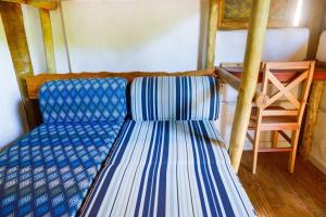 um sofá azul e branco num quarto em Quarto Praia Santiago São Sebastiao 03 em São Sebastião
