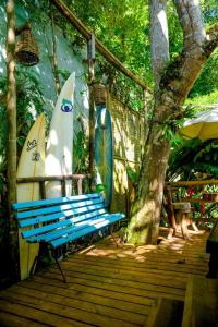 um banco azul sentado num deque de madeira com pranchas de surf em Quarto Praia Santiago São Sebastiao 03 em São Sebastião
