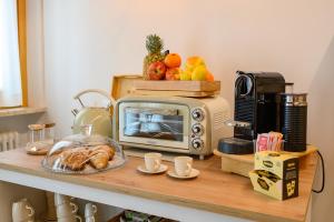 a kitchen counter with a microwave and a table with food at ILLASI DREAM ROOMS in Illasi