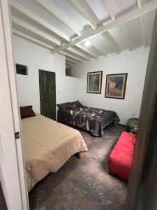 a bedroom with two beds and a red stool at Casa de jose in Manizales