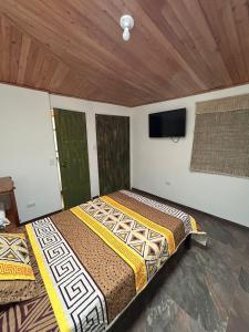 a bedroom with two beds and a flat screen tv at Casa de jose in Manizales