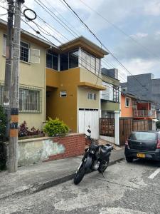 a motorcycle parked in a parking lot in front of a house at Casa de jose in Manizales