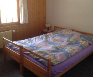 1 cama no hecha en un dormitorio con ventana en Apartment Panorama, en Arolla