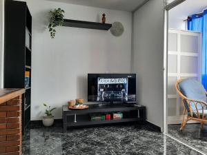 een woonkamer met een tv en een tafel bij Apartbeach Marina in Candelaria