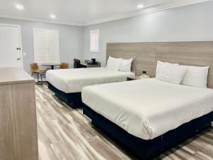 モントレーにあるローン オーク ロッジのベッド2台と机があるホテルの部屋