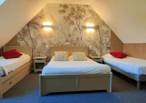 サン・マロにあるドメーヌ ドゥ ラ バルビーネのホテルルーム ベッド2台 赤い枕付