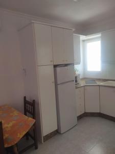 a kitchen with white cabinets and a white refrigerator at PARAÍSO in San Juan de los Terreros +34 photos