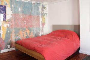 パリにあるCosy studio in Parisの壁画が飾られた部屋の赤いベッド1台